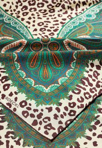 Silk scarf featuring a vibrant turquoise and orange paisley design against a beige background with brown leopard print accents.