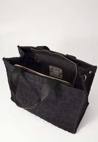 Borsa tote in tessuto nero con lettering impresso, zip dorata e molteplici scomparti, tra cui una tasca con un'etichetta decorativa all'interno.