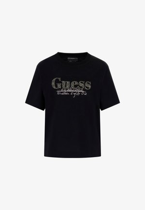 Schwarzes Baumwoll-T-Shirt mit rundem Halsausschnitt und kurzen Ärmeln. Besitzt ein glitzerndes "Guess"-Logo und den Text "Established Nineteen Eighty One".