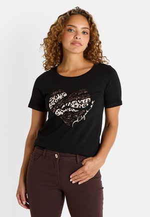 T-shirt noir avec un design en forme de cœur, featuring un imprimé léopard et des accents scintillants. Manches courtes, col rond et coupe ajustée.