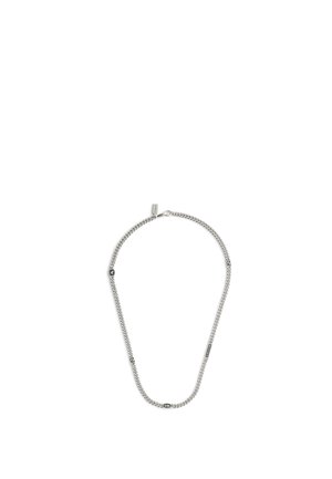 Silverfärgad kedjehalsband med små graverade rektangulära och hexagonala berlocker jämnt fördelade längs kedjan på en vit bakgrund.