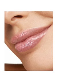 Primer plano de labios llenos con un brillo rosa translúcido y brillante, con textura suave y un contorno natural sutil.