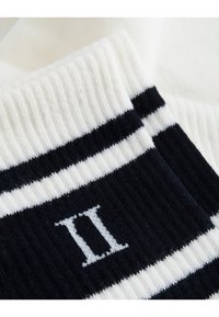 Black and white striped socks with ribbed texture, featuring a prominent white "II" detail on the black section. Soft cotton material.
