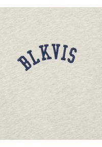 Tela gris claro con texto bordado en azul marino que dice "BLKVIS" dispuesto en forma de arco. Textura suave con un acabado liso.