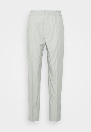 Pantalones de pierna recta de color gris claro con cintura elástica y pliegue frontal, exhibidos sobre un fondo blanco liso.