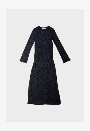Svart kjole med lange ermer og en innsvingt silhuett, med teksturert polkadot-mønster, rynkede detaljer på siden og en rund halslinning.