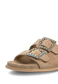 Sandale à semelle en daim beige avec deux grandes boucles décoratives ornées de cristaux transparents, bout ouvert et semelle rembourrée.