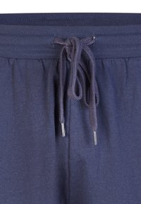 Navyblauwe sweatpants met geribbelde tailleband en geknoopte drawstring met metalen aglets in het midden aan de voorkant.