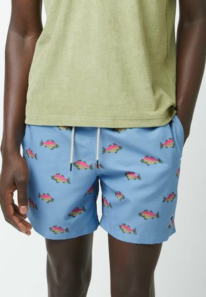 Costume da bagno azzurro chiaro con motivo ripetuto di pesci in rosa, verde e nero. Vita elastica con coulisse e tasche laterali.