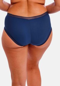 Marineblauwe hoog-gesneden onderbroek met een gladde textuur en delicate kanten afwerking aan de tailleband, met een volledige dekking achter.