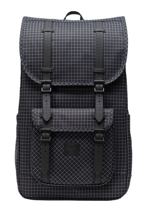 Zaino nero realizzato in tessuto imbottito con motivo a diamante, dotato di spallacci regolabili, una tasca frontale e chiusura a patta superiore.