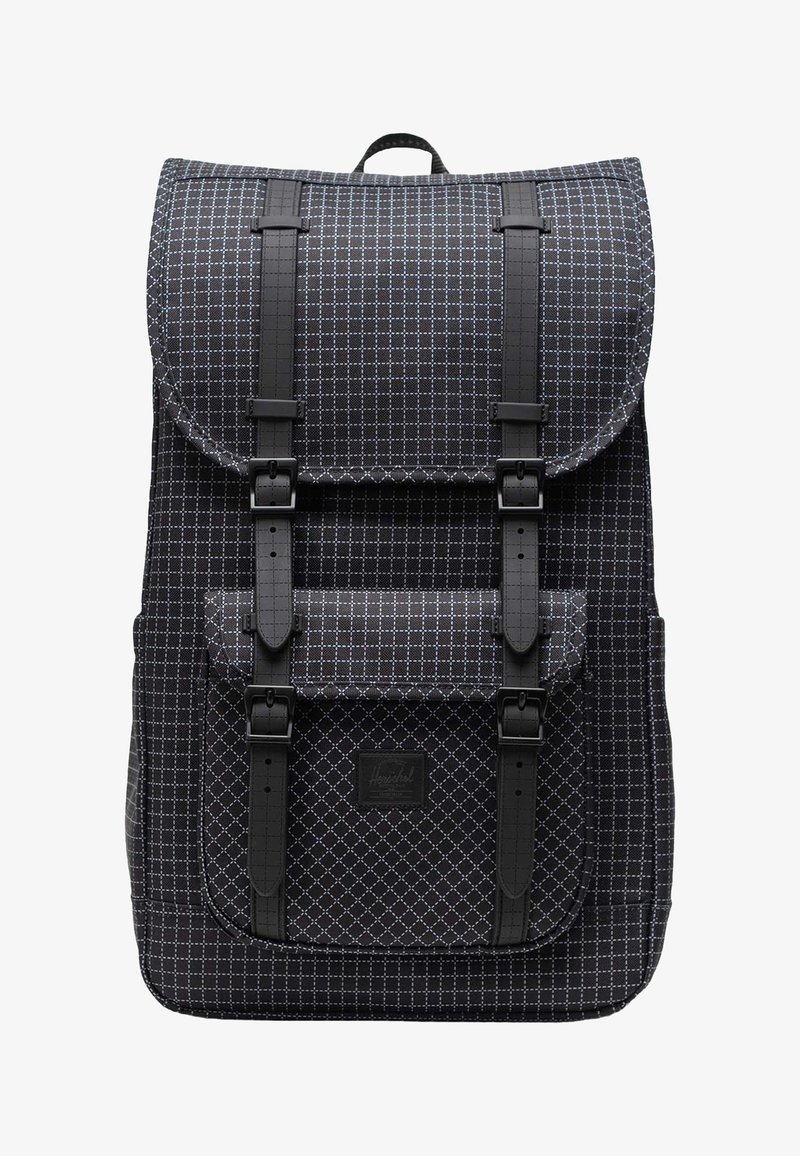 Svart ryggsäck tillverkad av vadderat tyg med diamantmönster, utrustad med justerbara remmar, en framficka och ett överfång på toppen.