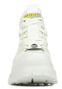 Weiße Sneakers mit einer strukturierten Oberseite und einer massiven Sohle. Sie besitzen auffällige Schnürsenkel, ein Logo-Tag und ein kontrastierendes gelbes Etikett.