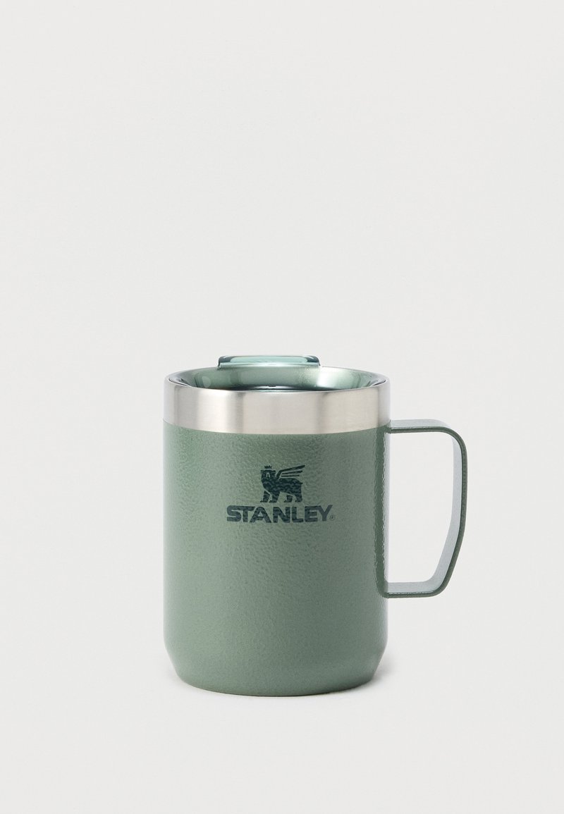 Πράσινο θερμικό κύπελλο Stanley από ανοξείδωτο χάλυβα με λαβή και καπάκι σε λευκό φόντο.