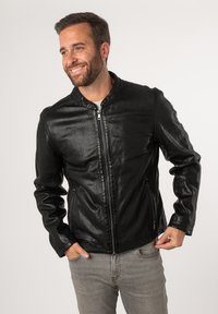 Giacca nera in ecopelle con colletto rialzato, zip frontale e tasche laterali, caratterizzata da una finitura liscia e testurizzata e da un design aderente.