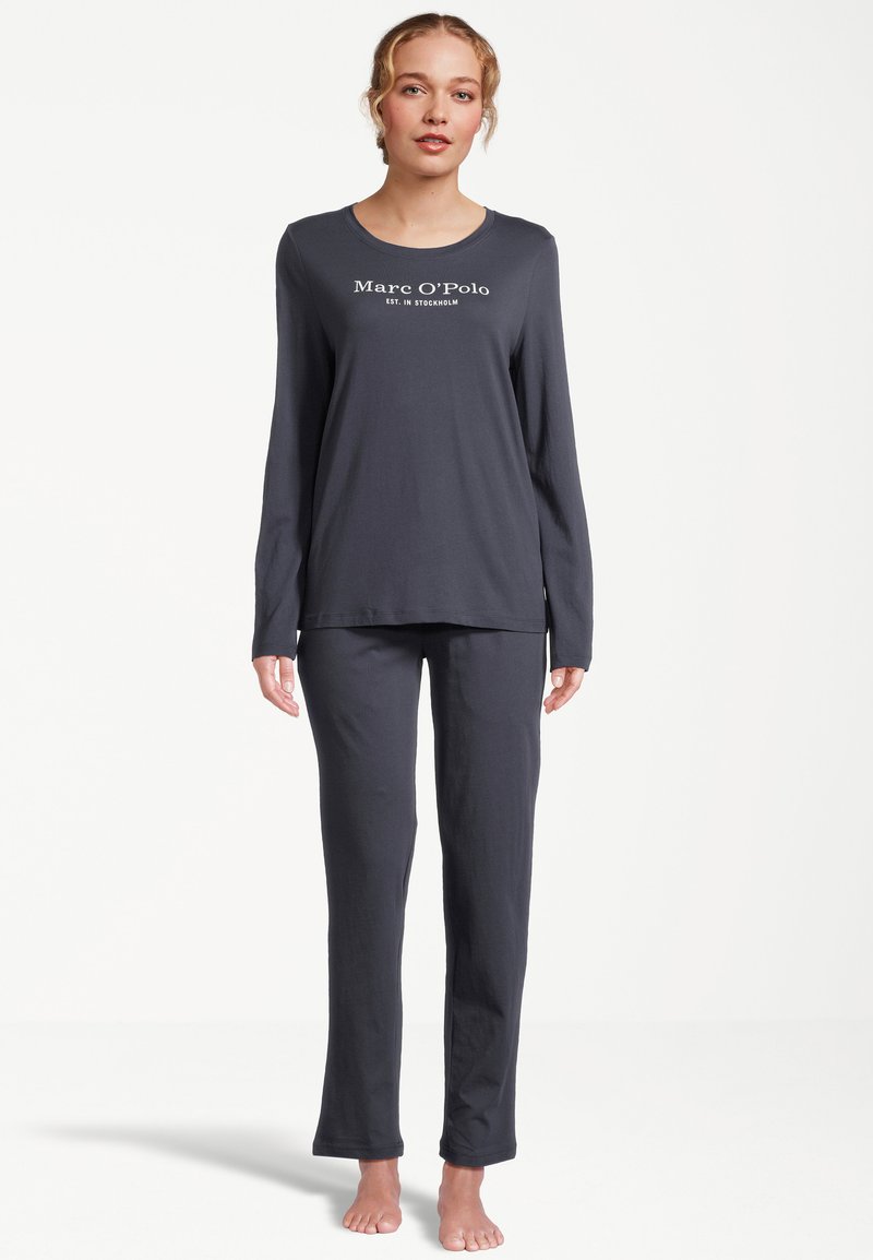 Mörkgrå pyjamasset med långa ärmar som har rund halsringning och varumärkeslogo på toppen. Mjukt tyg med raka byxben.