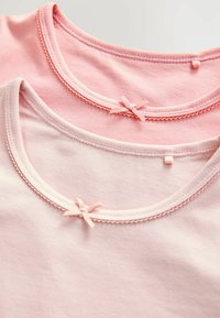 To-lagede T-shirts i varierende nuancer af pink, fremstillet af blødt bomuldsstof, med rund halsudskæring og små sløjfer som accenter.