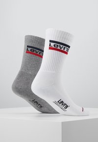 Levi's Socken in Grau und Weiß; gerippte Textur, sportlicher Schnitt, mit einem markierten Streifen in Marineblau und Rot am oberen Rand und Logo an der Sohle.