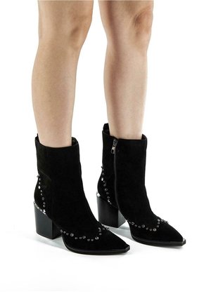 Bottines en daim noir à bout pointu, talon carré, et clous argentés décoratifs sur les côtés. Dotées d'une fermeture éclair latérale.