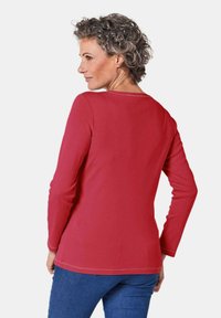 Langsleeve t-shirt in levendig rood katoen met een ronde halslijn, met een rechte snit en contrasterende stiksels aan de zoom.