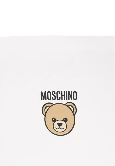 Hvidt stof med en tegneserie-bjørnehovedgrafik i beige, med fed sort tekst "MOSCHINO" over bjørnen.