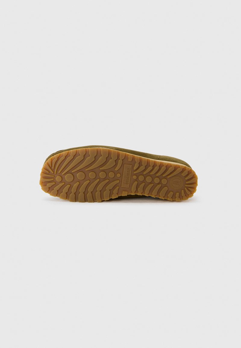 Suela de goma marrón con un patrón texturizado, que presenta surcos profundos y acentos circulares para mayor tracción. Diseño robusto y duradero.