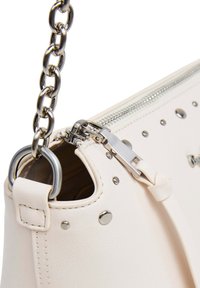 Borsa a tracolla in pelle bianca con dettagli in metallo color argento, borchie, tracolla a catena e chiusura con cerniera e dettaglio con linguetta.