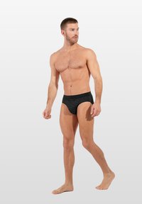 Schwarze Badebriefs aus strukturiertem Stoff mit geometrischem Muster. Sie haben eine enganliegende Passform und einen kontrastierenden Hüftbund.