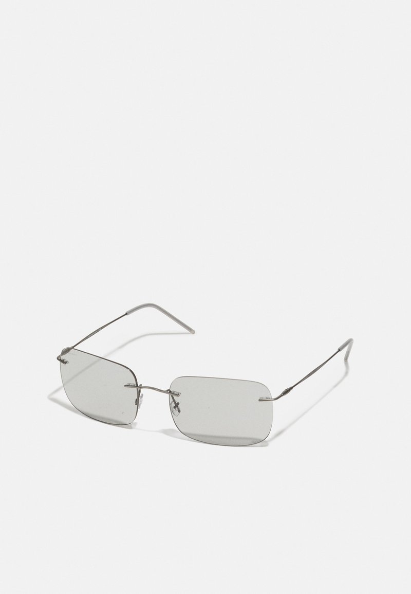 Lunettes de soleil rectangulaires grises avec des montures en métal argenté fines, mettant en avant des branches droites et un design minimaliste, sans motifs ni logos visibles.