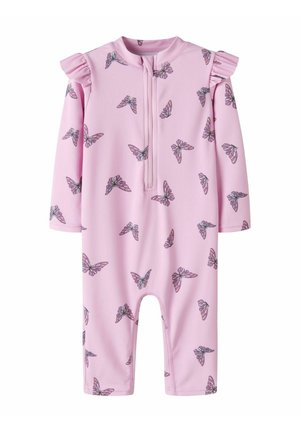 Rózsaszín csecsemő rugdalózó hosszú ujjakkal, elöl cipzárral, vállán fodrokkal és a szöveten színes pillangómintával.