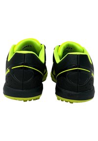 Scarpe sportive nere con accenti verde brillante, tomaia in tessuto testurizzato, colli imbottiti e suole in gomma con motivi di grip.