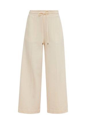 Pantalones de pierna ancha beige, confeccionados en una tela suave, con una cintura elástica y cordón de ajuste con puntas metálicas en los extremos. Textura suave.