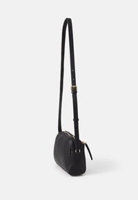 Borsa a tracolla in pelle nera con superficie texturizzata, dotata di chiusura a zip, tracolla regolabile e dettagli in metallo dorato.