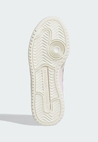 Shoe sole with textured rubber, featuring wavy patterns and a circular design at the heel. Color: pale cream, with subtle pink accents.
