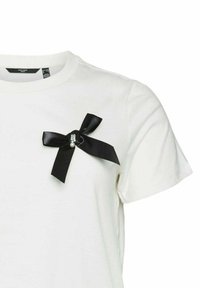 T-shirt bianco in cotone con un fiocco in satin nero e un accentuazione perlata sul lato sinistro del petto. Maniche corte e scollatura girocollo classica.