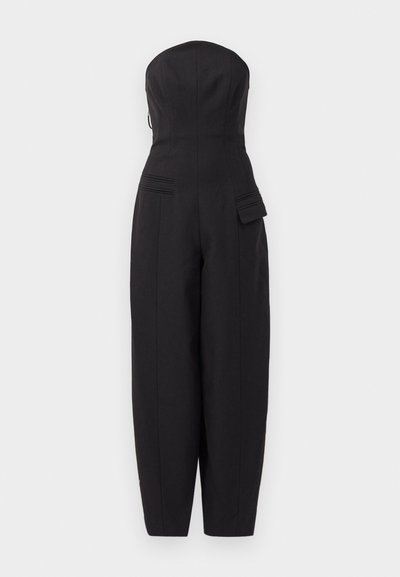 Must mustavööta ilma rihmadeta jumpsuit, millel on sobiv kehaosa, laiad püksid ja küljetaskud, millel on sissetõmme detail. Valmistatud sujuvast kangast.