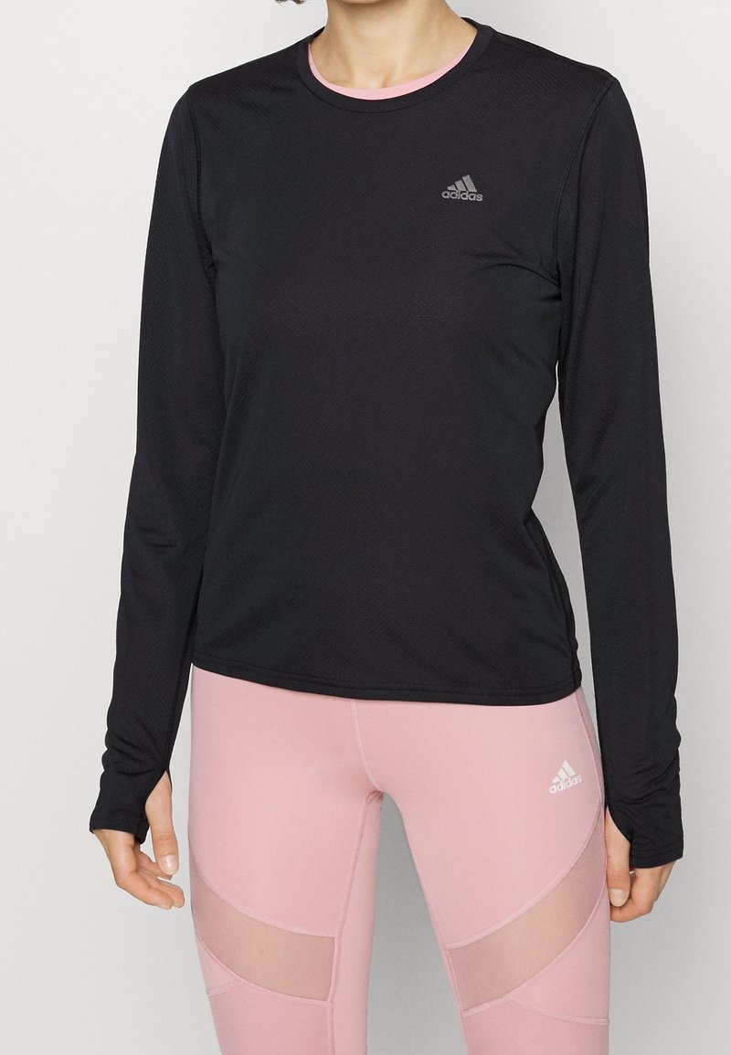 Schwarzes langärmliges Sportshirt aus strukturiertem Material, runder Ausschnitt und ein kleines weißes Adidas-Logo auf der Brust.