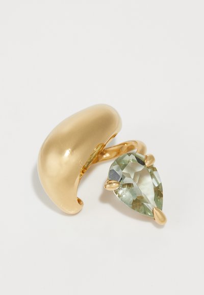 Gold-tone metal ring featuring a smooth, curved design with a large, pear-shaped green gemstone set into prongs.