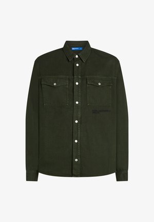 Tamsiai žalia džinsinio audinio marškiniai su ilgomis rankovėmis, dviem krūtinės kišenėmis, spaudėmis ir šiek tiek faktūriniu paviršiumi. Yra logotipo detalė netoli apdailos.