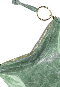 Groene textuur tas met een gouden rits, opening aan de bovenkant en een ronde hardwareaccent op de riem. Gladde, glanzende afwerking.