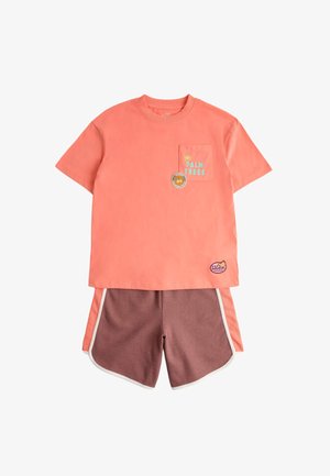 Koralfarvet t-shirt med korte ærmer med "Palm Trees" og lille solgrafik på lommen, kombineret med mauve atletikshorts med koralfarvede side-striber.