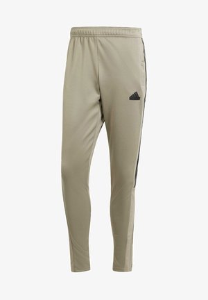 Light khaki athletic pants with a tapered fit, elastic waistband, side pockets, and black stripe accents. Features an embroidered logo on the thigh.