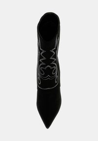 Botine negre din suede, cu vârful ascuțit și cusături decorative din argint pe laturi. Textură netedă cu o siluetă ajustată.