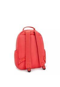 Mochila roja de tela con respaldo acolchado, correas ajustables y bolsillos laterales. Diseño sencillo con un asa superior para mayor comodidad al llevarla.