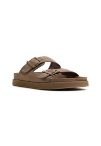 Brown suede slide sandals with dual adjustable buckles, cushioned footbed, and rubber sole. Suitable for casual wear.