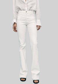 Jeans bianchi a palazzo realizzati in denim, con chiusura frontale a zip e bottone, caratterizzati da una texture liscia e un design minimale.