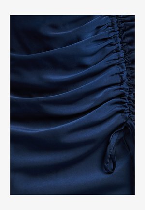 Navy satin fabric with gathered detailing, featuring smooth texture and subtle sheen. Accents include drawstring ties on the side.
