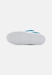 Semelle de basket en daim bleu avec une semelle extérieure en caoutchouc blanc présentant un motif en losange pour l'adhérence. Design simple, lignes épurées, marquage minimaliste.