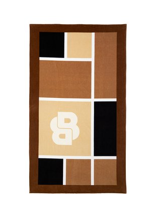 Tapis rectangulaire avec des blocs géométriques marron, beige et noir, des lignes de grille blanches, et un double "B" stylisé blanc au centre du bloc beige.