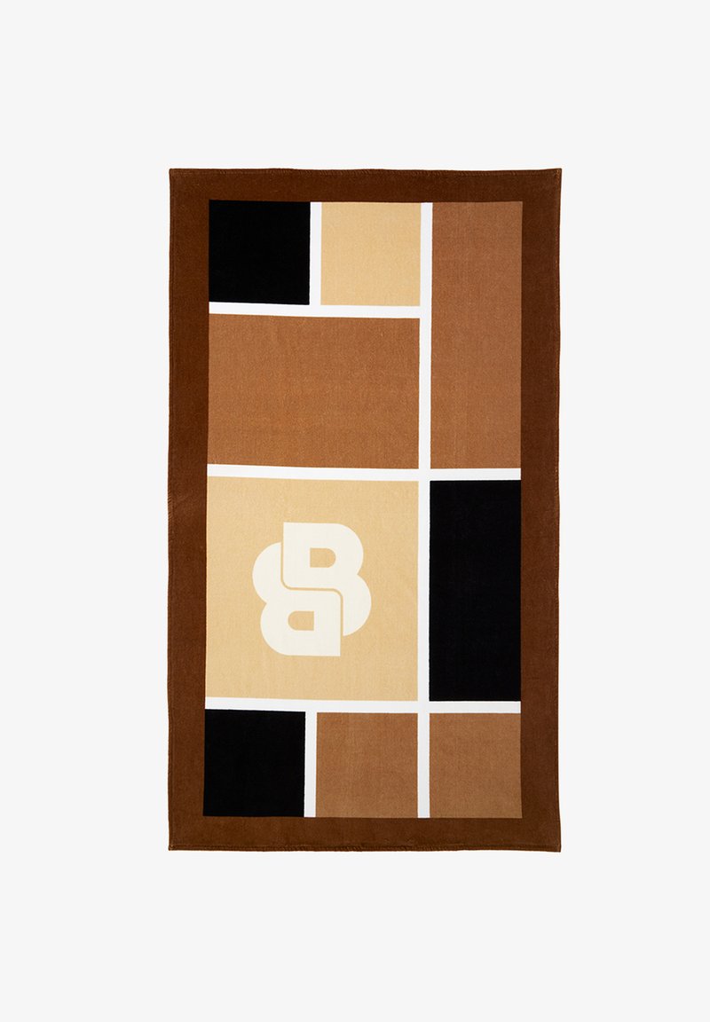 Tapis rectangulaire avec des blocs géométriques marron, beige et noir, des lignes de grille blanches, et un double "B" stylisé blanc au centre du bloc beige.